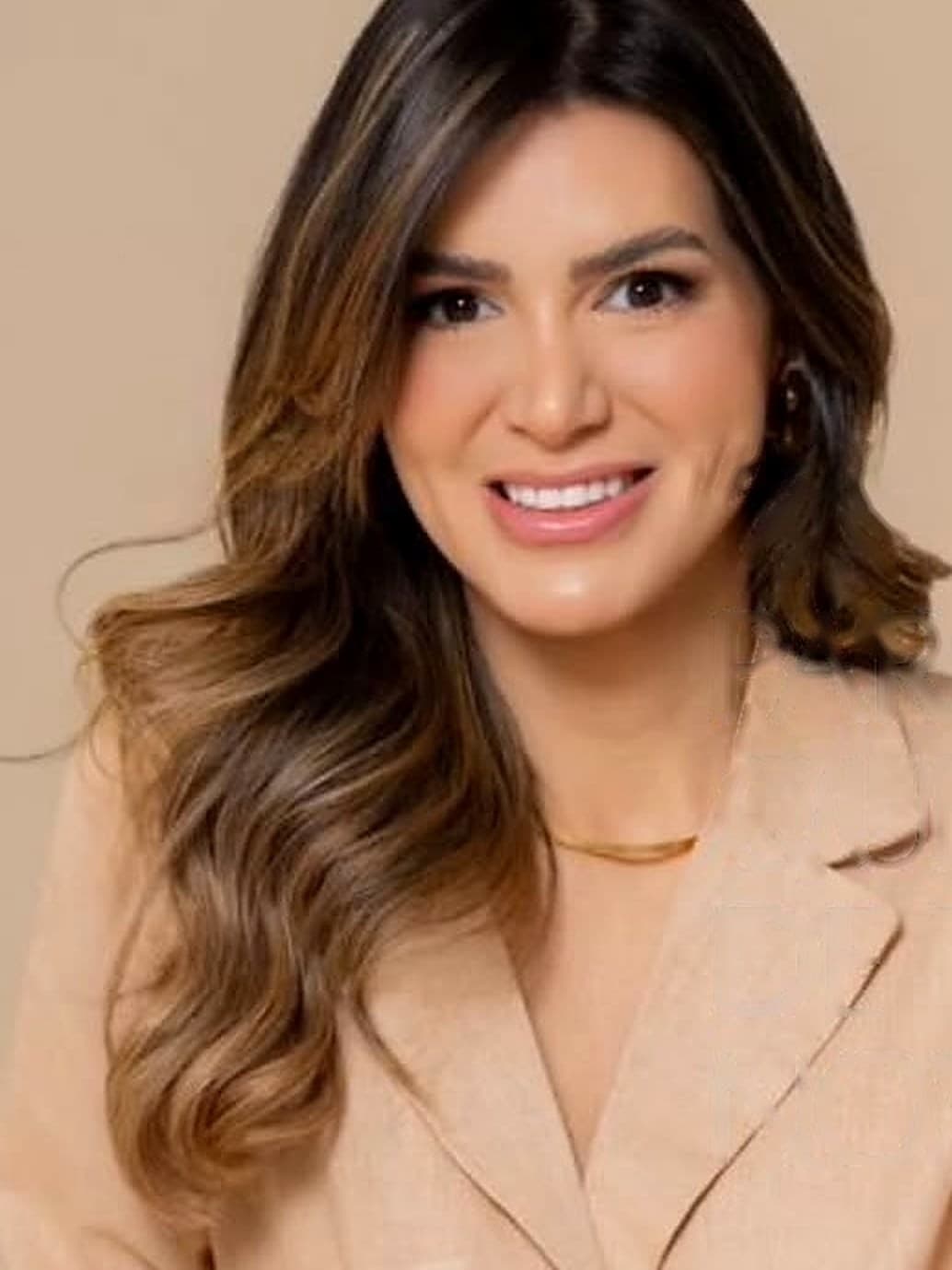 Dra. Raíssa Campelo sorrindo, em ensaio profissional em tons bege